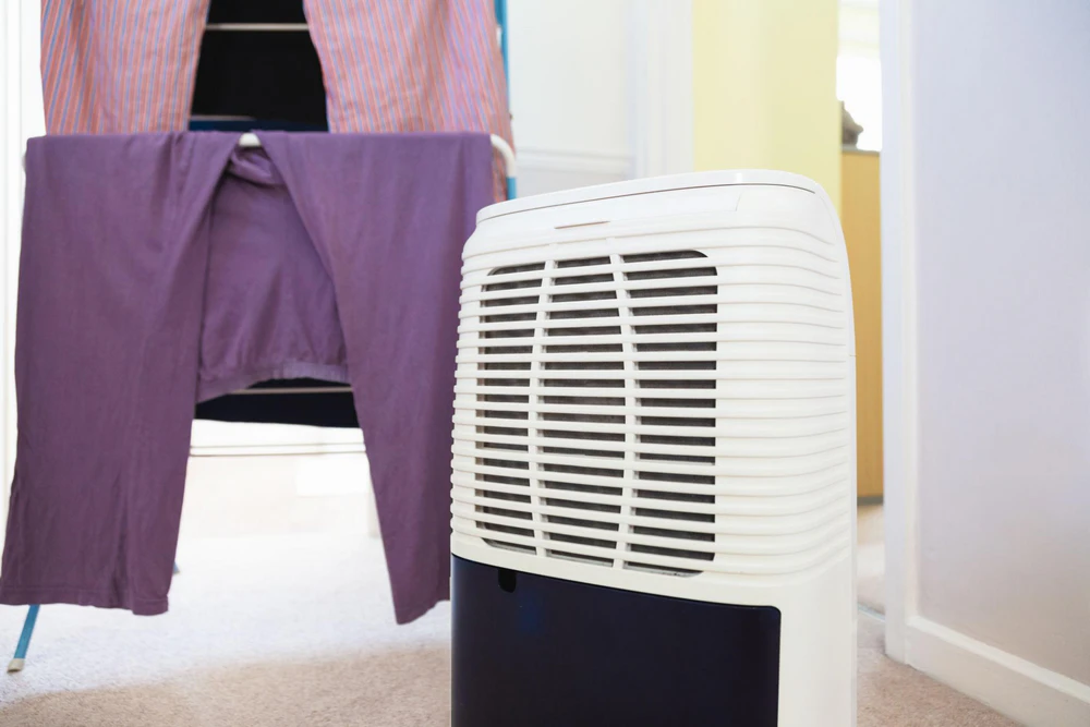 Using a dehumidifier to dry laundry indoors on a clothes airer