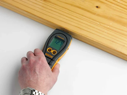 Moisture meter measuring timber moisture content during structural flood drying assessment
