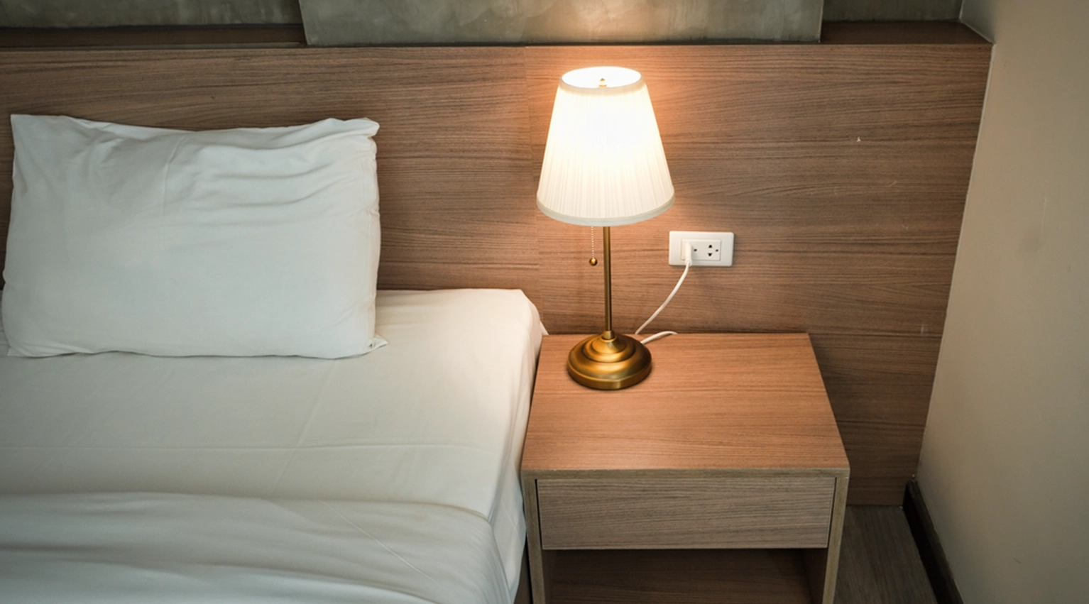 Bedbugs like to hide in furniture cracks and crevices A picture of a hotel bed and side cabinet