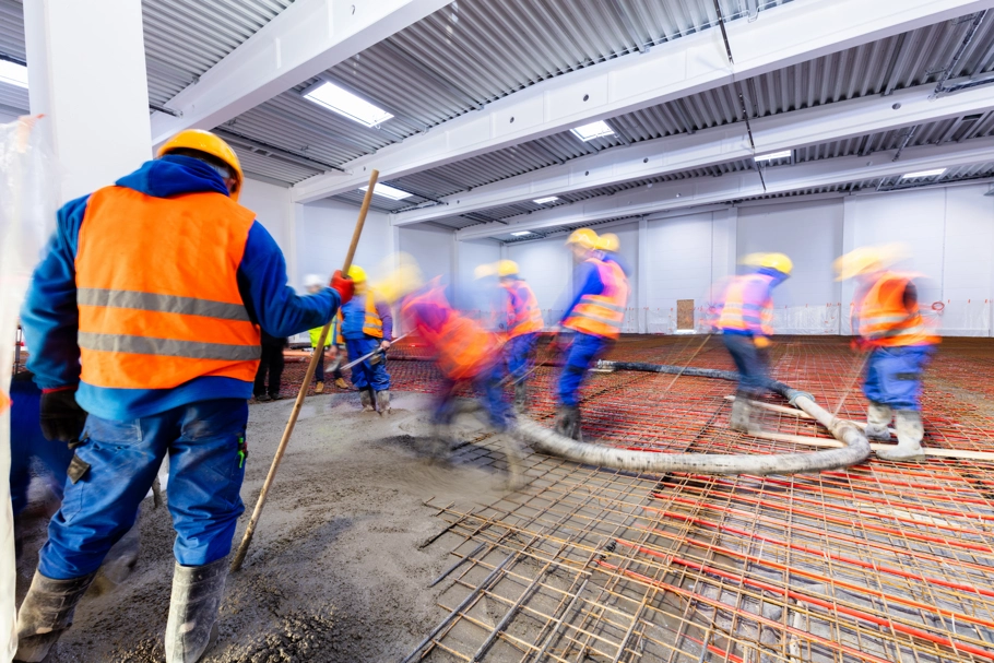 Workers laying screed floor